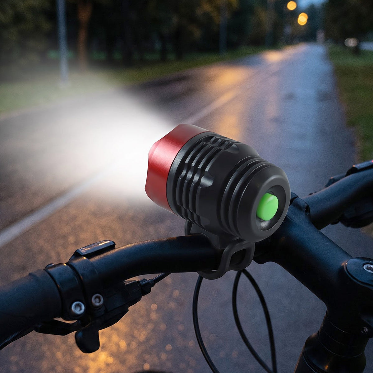 A red and black bicycle headlight with a green button illuminates a dark road from a bike's handlebars, with a small inset