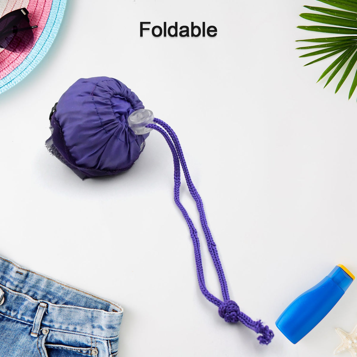 The purple foldable shopping bag is shown folded into a compact shape with a drawstring and clip.