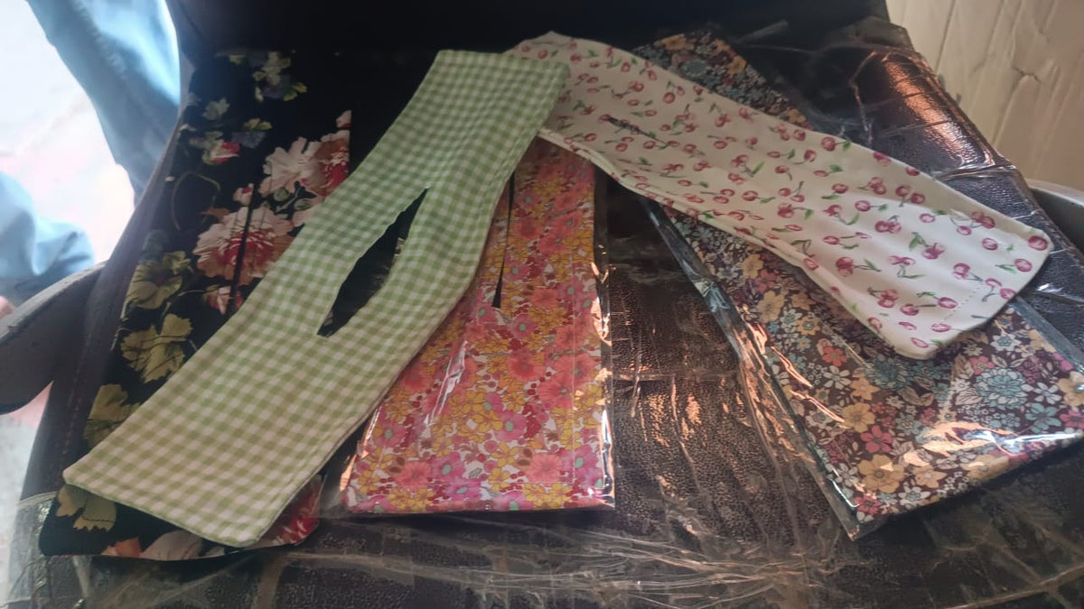Multiple floral and checkered patterned headbands, some in packaging, on a dark surface.