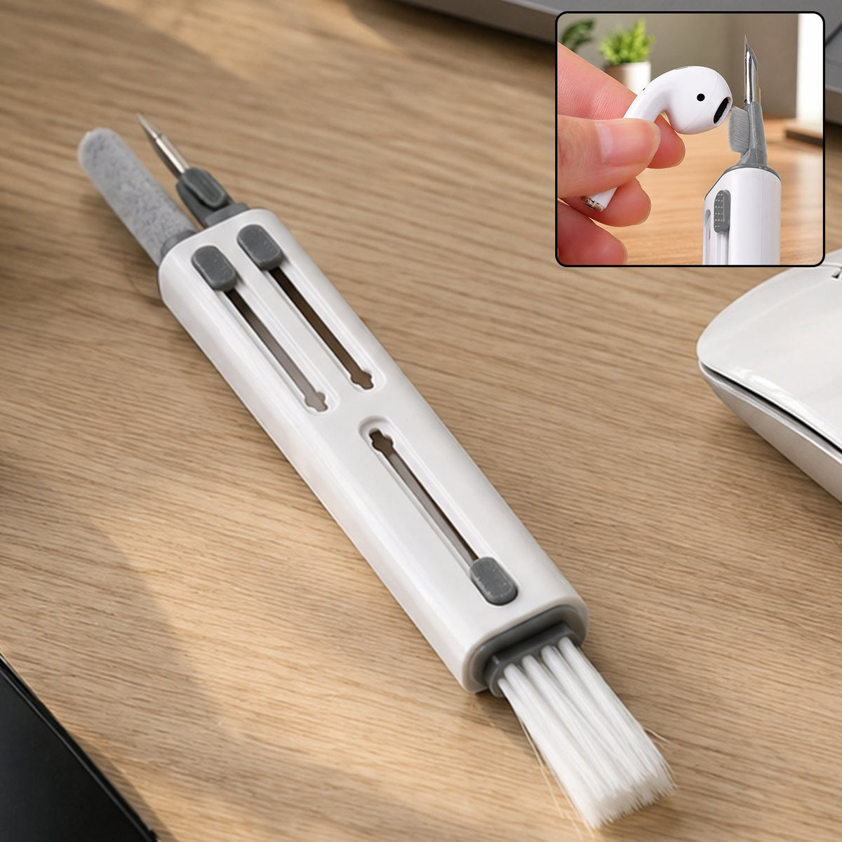 White and gray multi-tool cleaning pen with brush, pointed tool, and soft brush on a wooden desk.