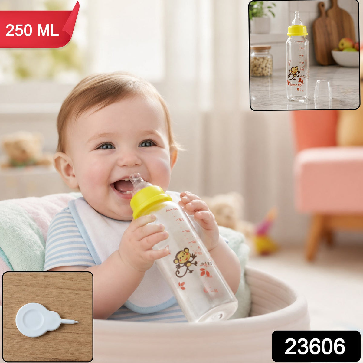 A happy baby in a high chair drinks from a clear glass baby bottle with a yellow nipple and monkey design, with text