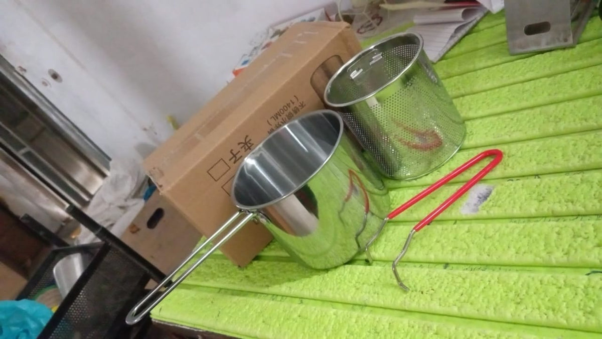 Close-up of the polished stainless steel surface of the deep frying pot.