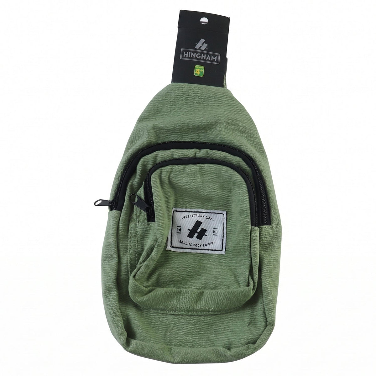 A green canvas sling bag with a black strap and zippers, featuring a white label, displayed on a white background.